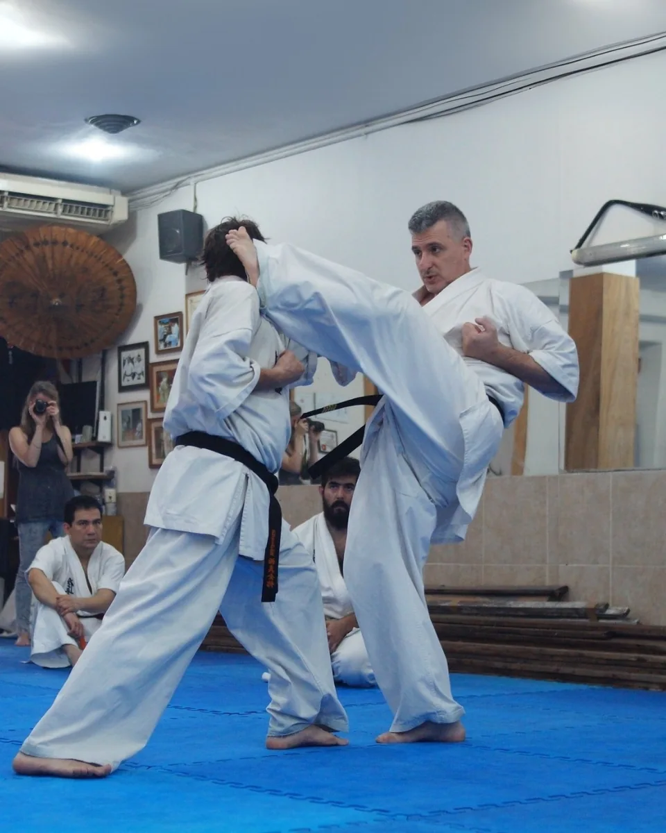 Demostración de una técnica de pierna con un compañero.