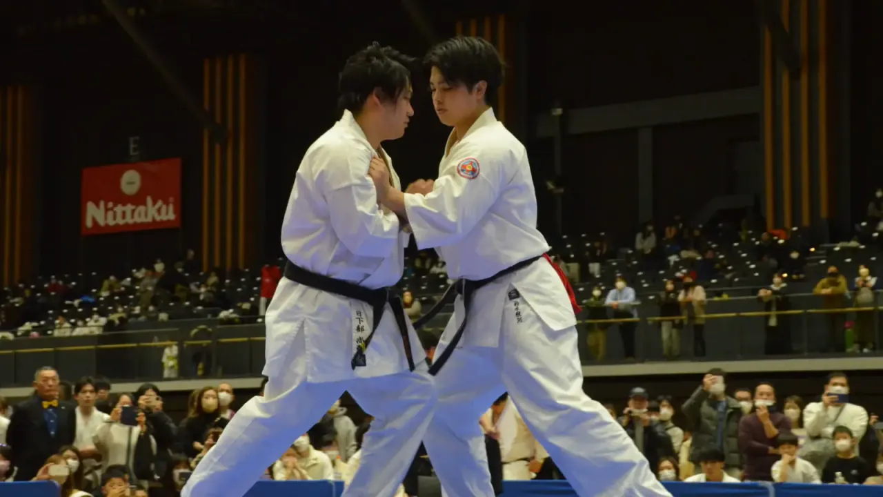 Dos practicantes frente a frente durante un combate de kumite en un campeonato.